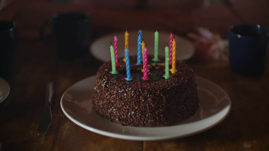 The chocolate birthday cake is full of candles