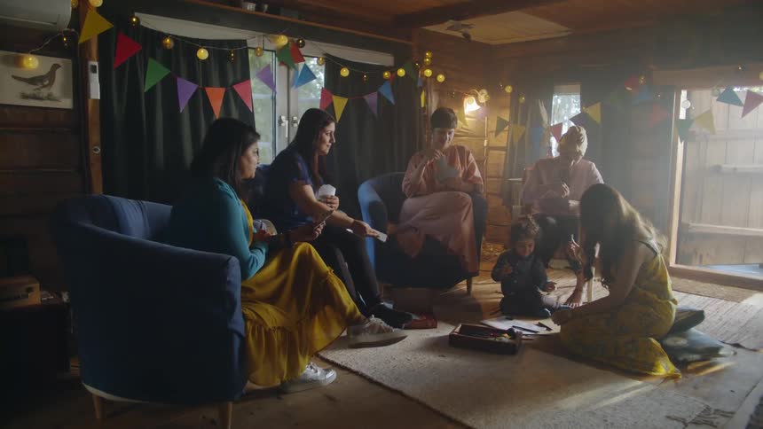 The woman sit together playing cards