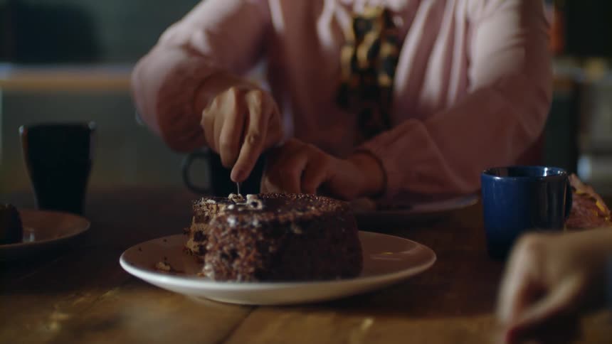 A woman cuts and serves a piece of cake