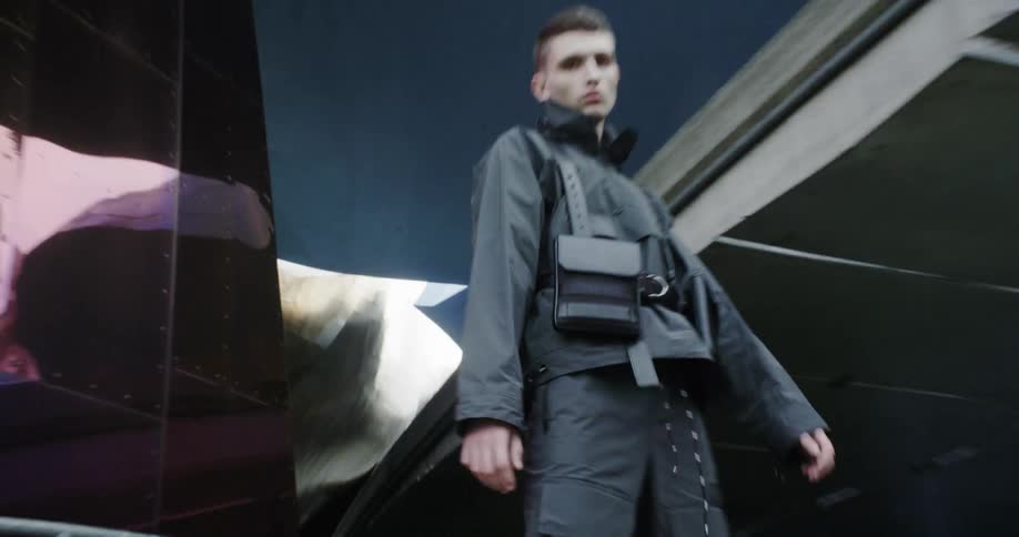 A man wears heavy boots next to a city building