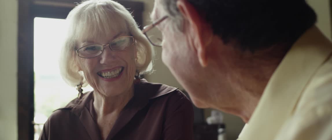 An older man and woman talking, smiling and laughing