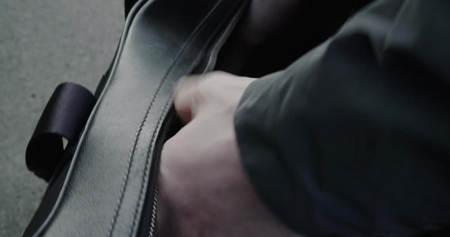 A man opens a leather bag