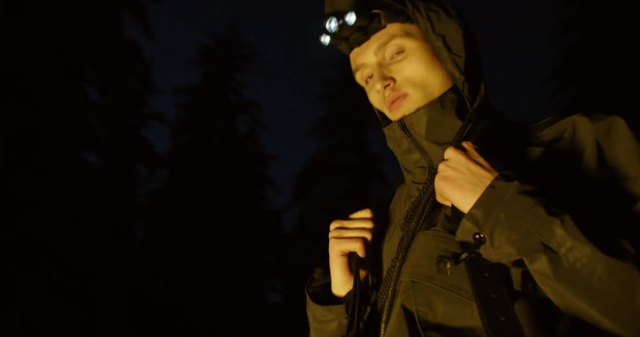 A man wears a headlamp while hiking in the dark