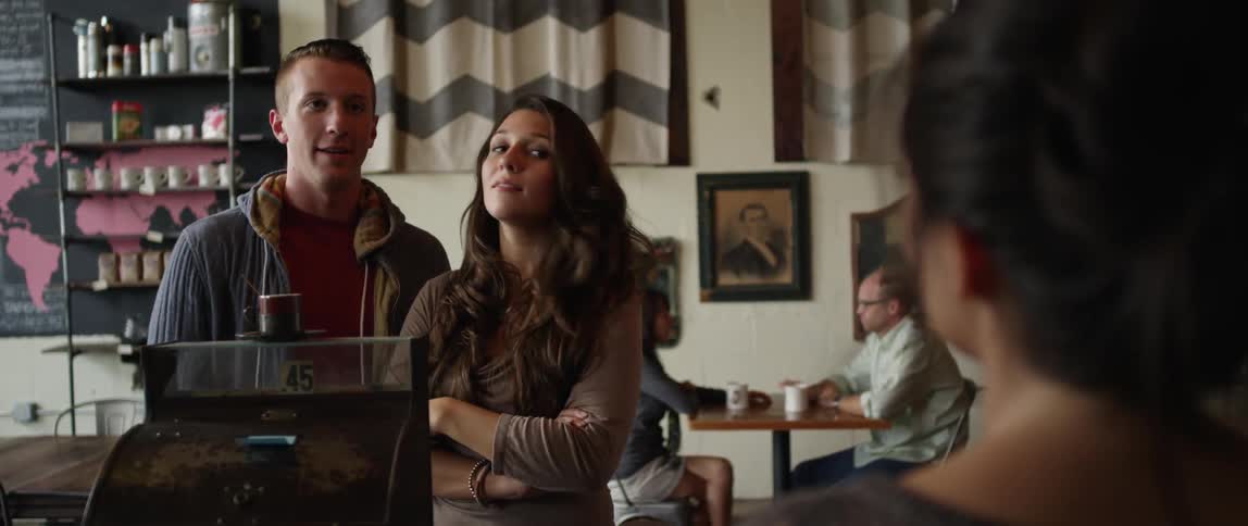 A man and woman are giving order at a coffee shop