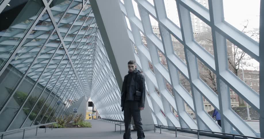 A man poses next to a city building