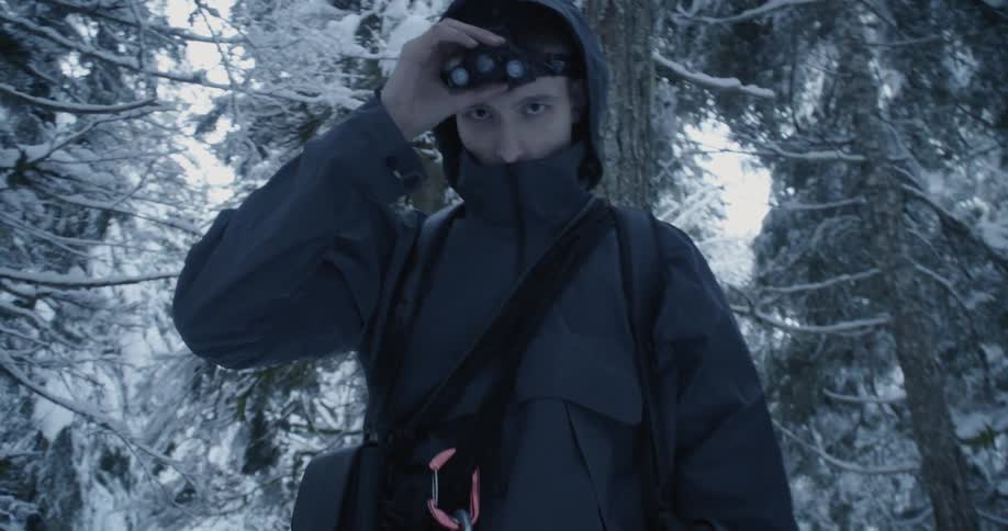 A man hikes in a snowy forest