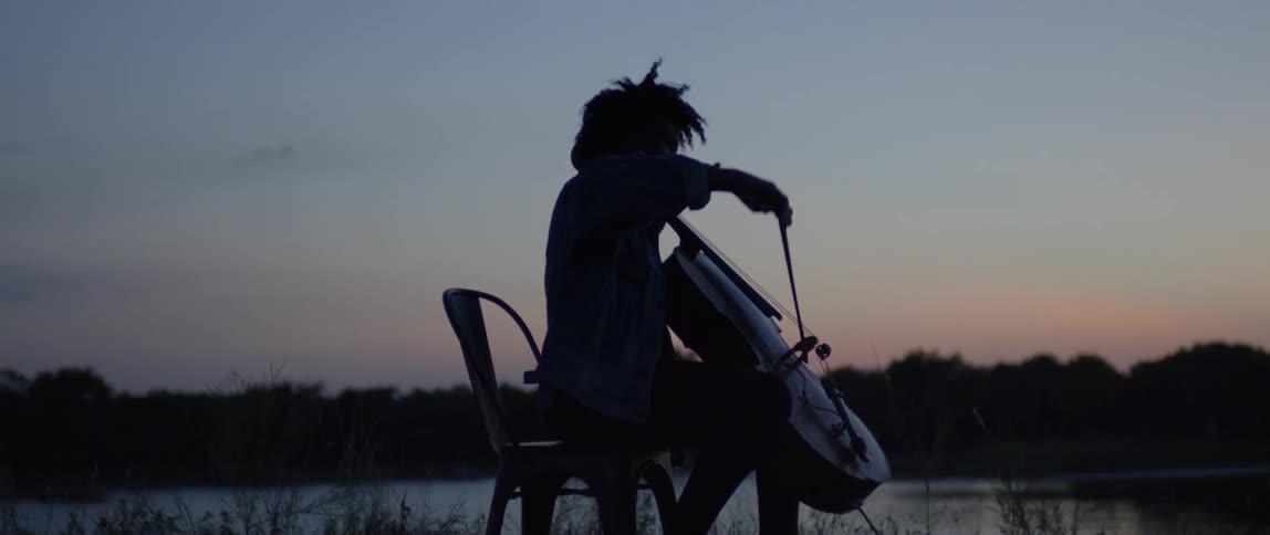The woman sits down to play the double bass at dawn