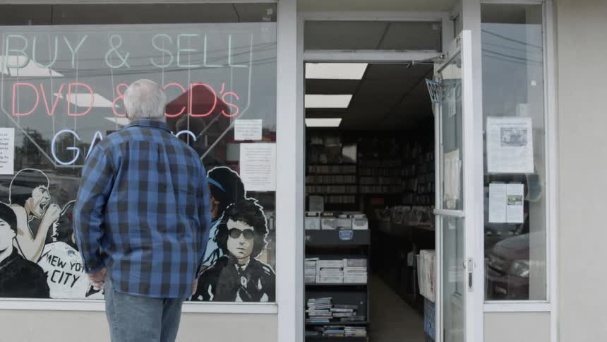 A man walks by a music store