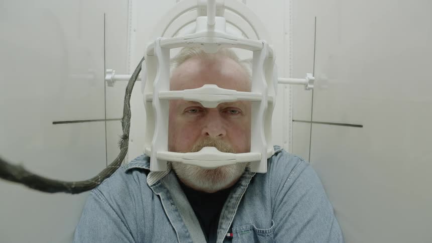 A man wearing a contraption on his head that lifts him up
