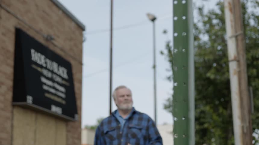 The man walks past the building on a windy day