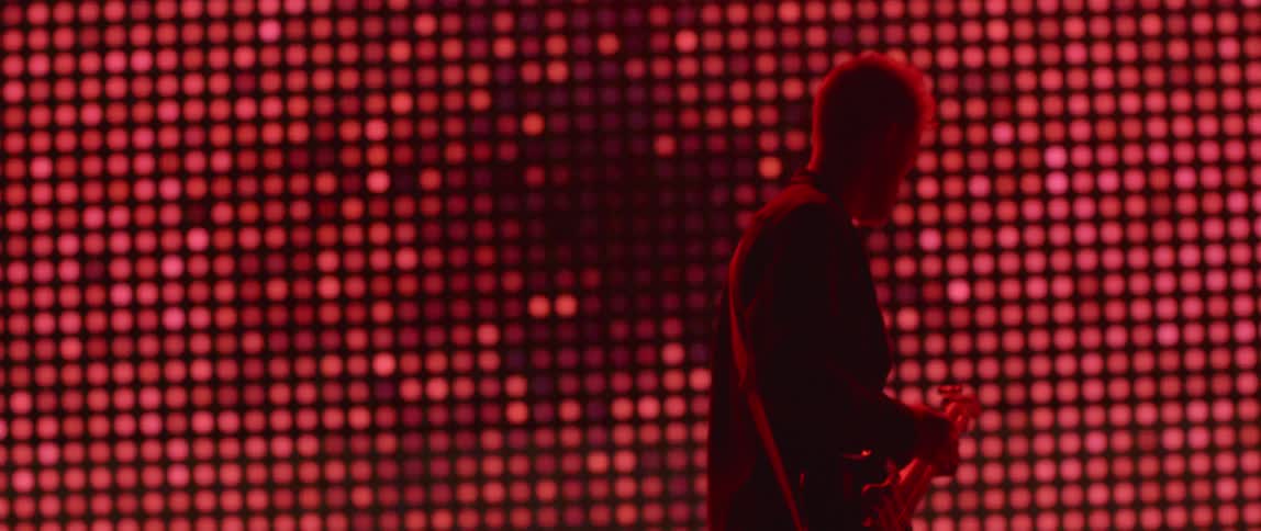 The man is playing guitar on stage