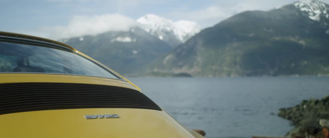 Man Driving Classic Yellow Sports Car
