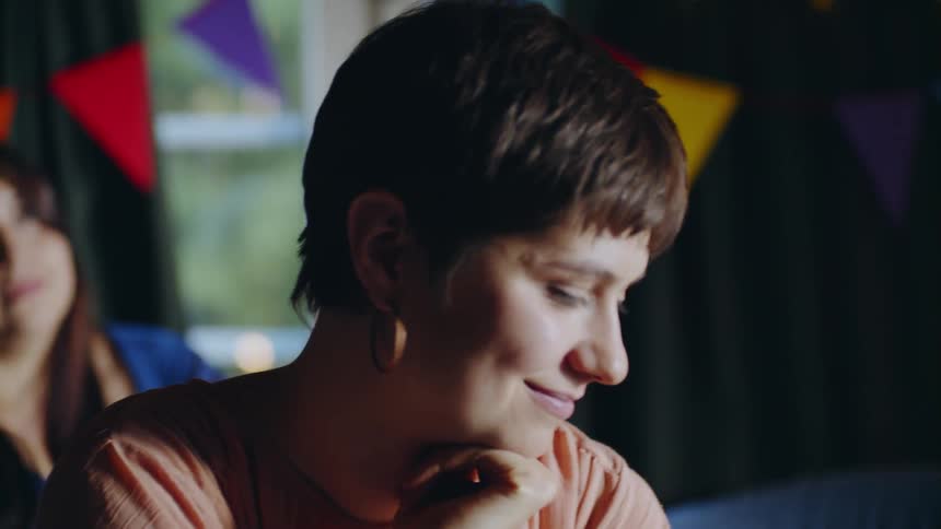 The woman smiles and looks down