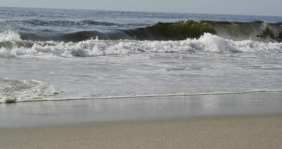 Ocean waves wash ashore a sandy beach