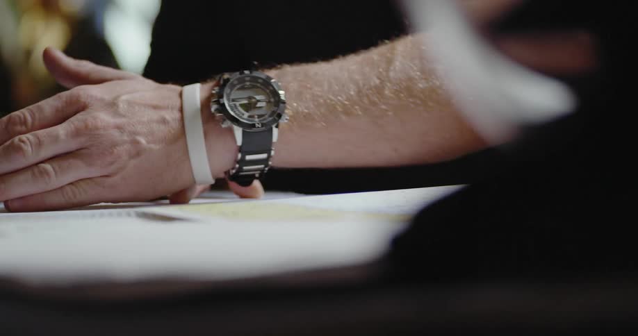 A man points and gestures at a document on a desk
