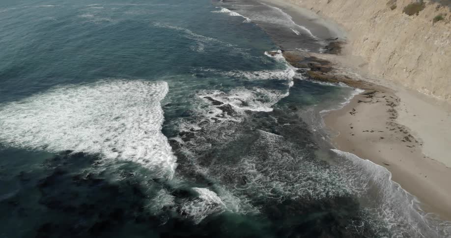 Ocean waves flow towards a sandy beach