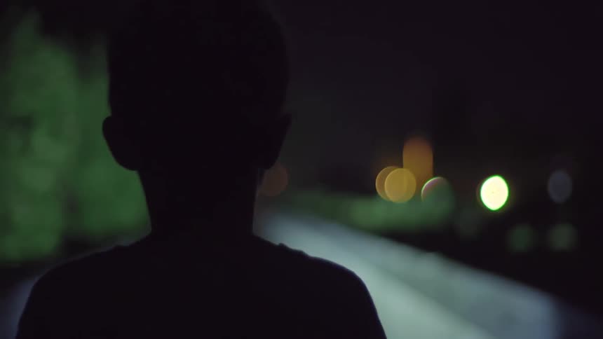A boy with a flashlight is walking down a pathway
