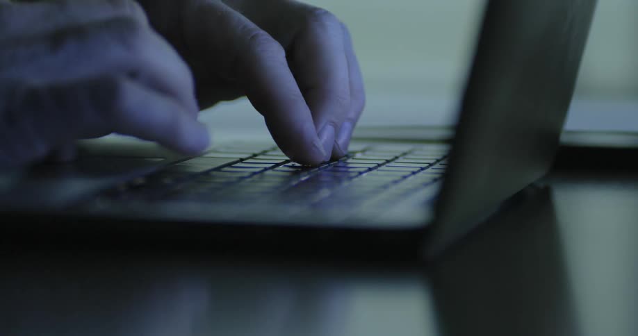 A man types on a laptop