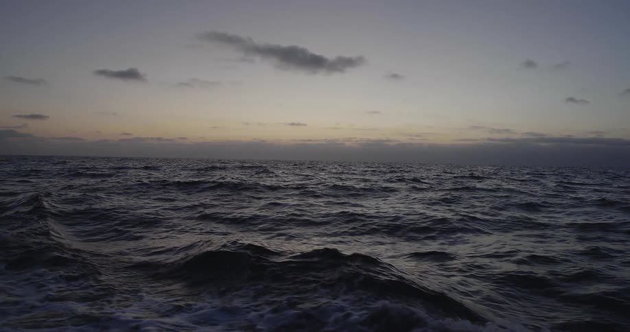 Sun sets over the flowing ocean