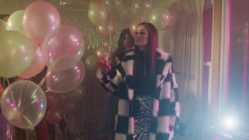 Men and woman play with balloons at a party