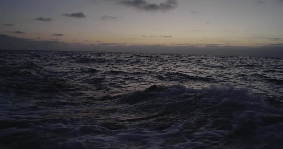 Waves flow on an ocean at sunset