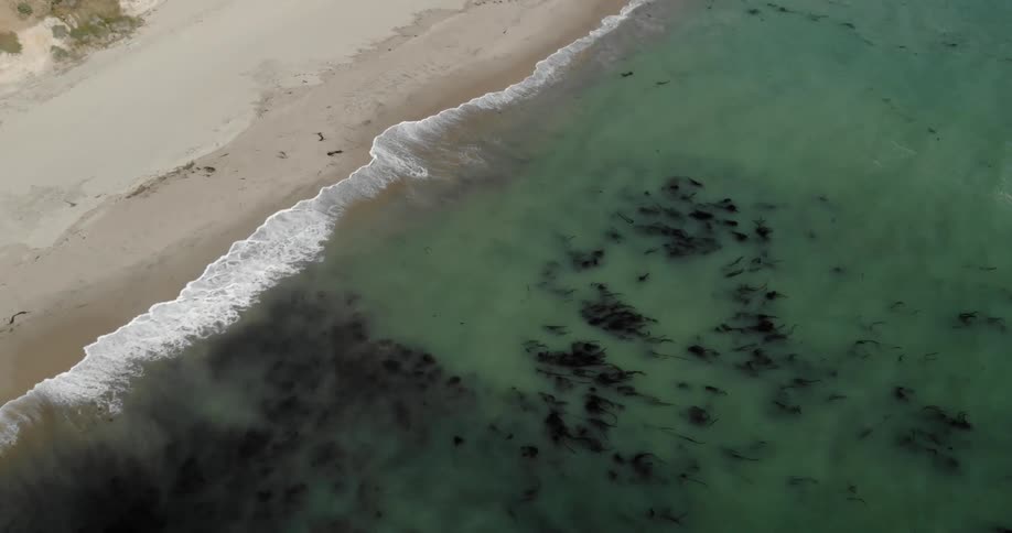 Ocean waves flow towards a sandy beach