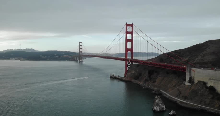 The vehicles drive over the golden gate bridge