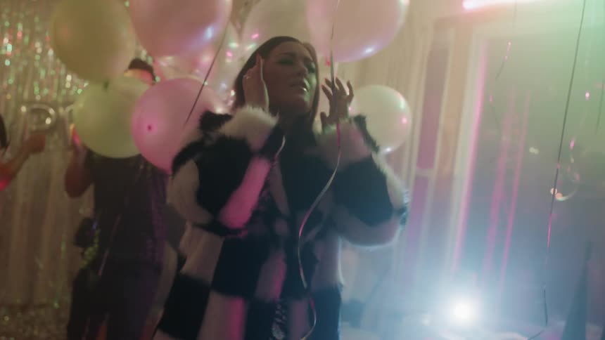 People dance at a party with balloons