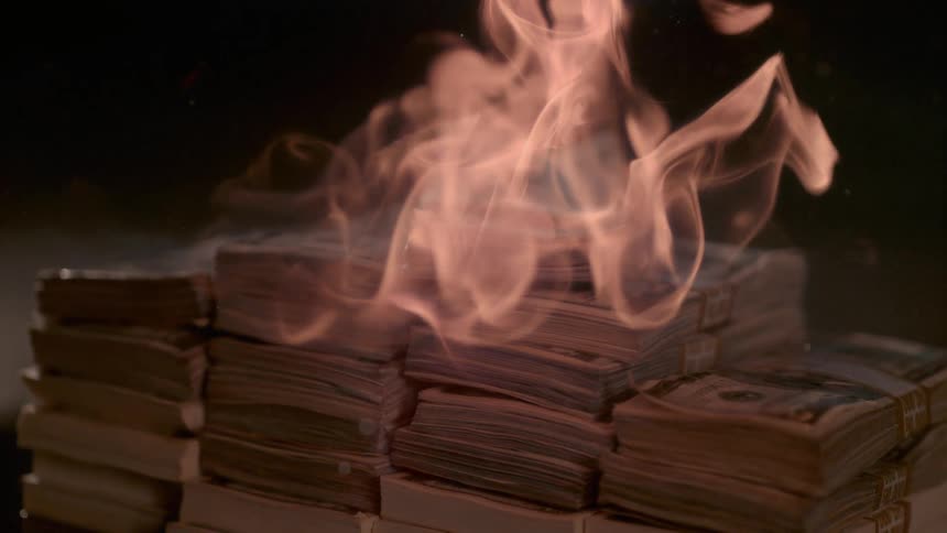 Fire burns a large stack of dollar bills