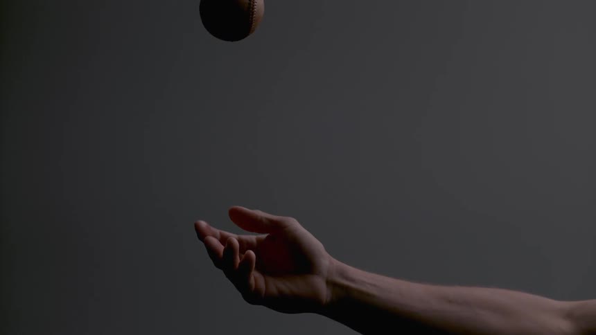 A man throws and catches a flaming baseball