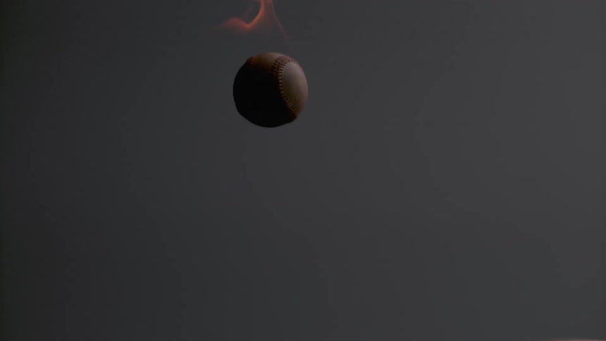 A man throws a flaming baseball