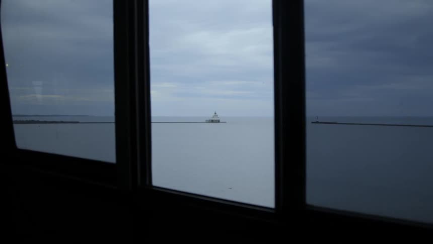 The entrance to the harbor is visible through a ferry window