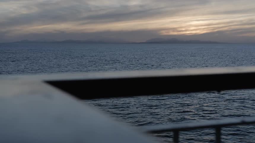 The boat sails at sunset in the rough waters