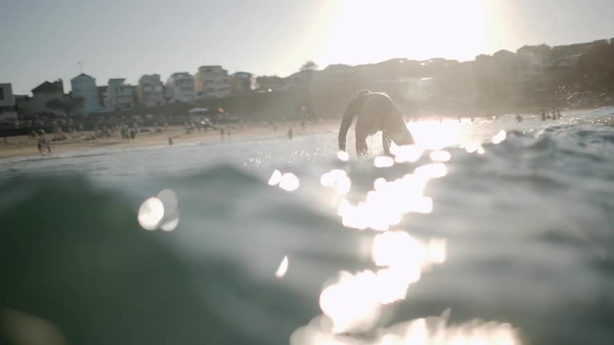 A woman is riding a wave near the shore