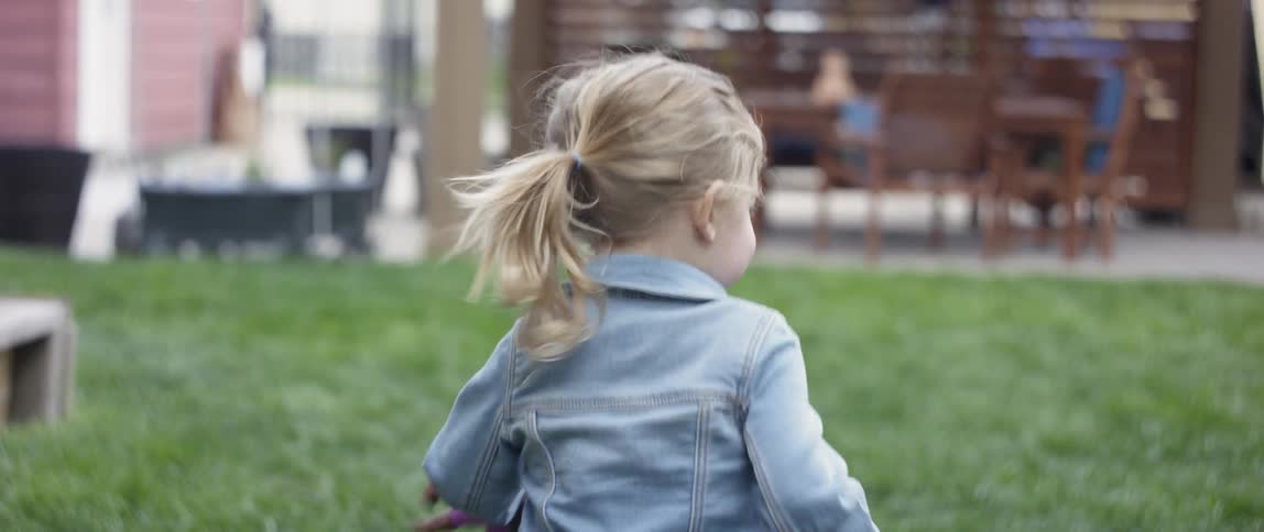 A young girl runs playfully towards the playground