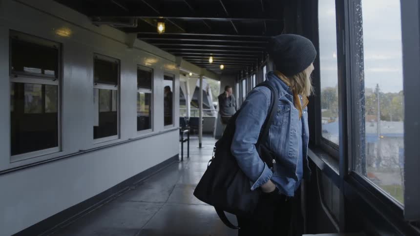 A woman looks out the window of a ferry