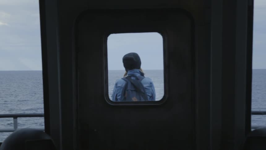 A person stands outside of the cabin of the ship