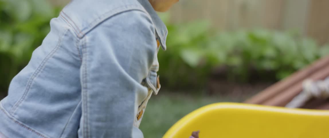 Young girl holds a small doll and then pushes it up a slide