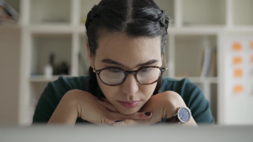 A woman uses a computer at a desk