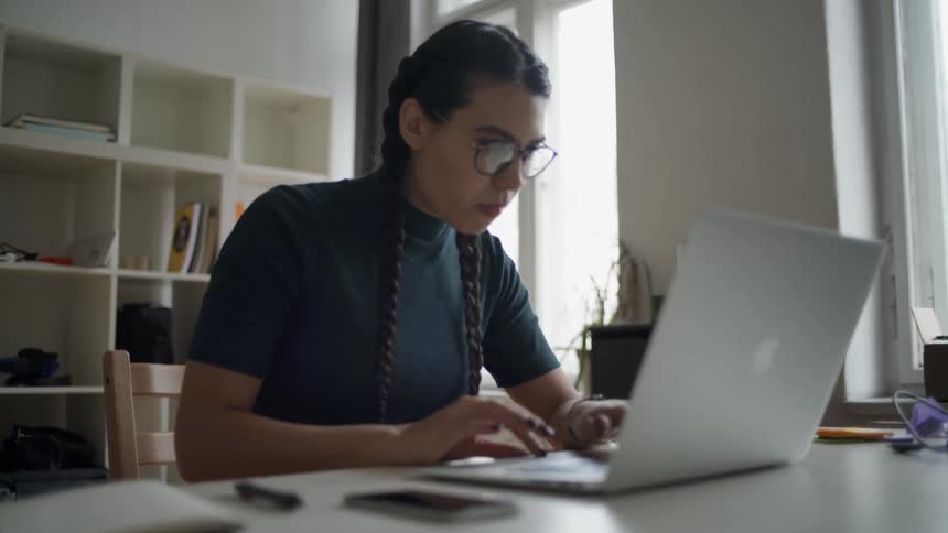 The woman types fast on the laptop
