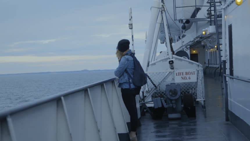 A woman rides on a ship at sea