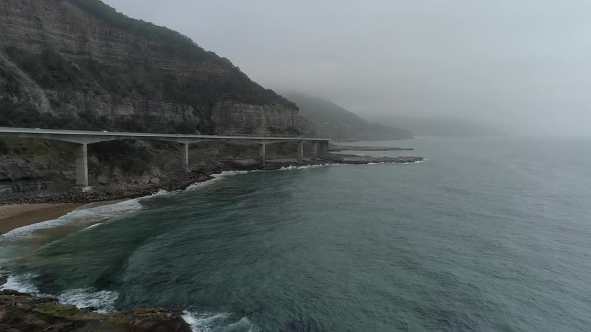 The tide flows towards the rocky shore