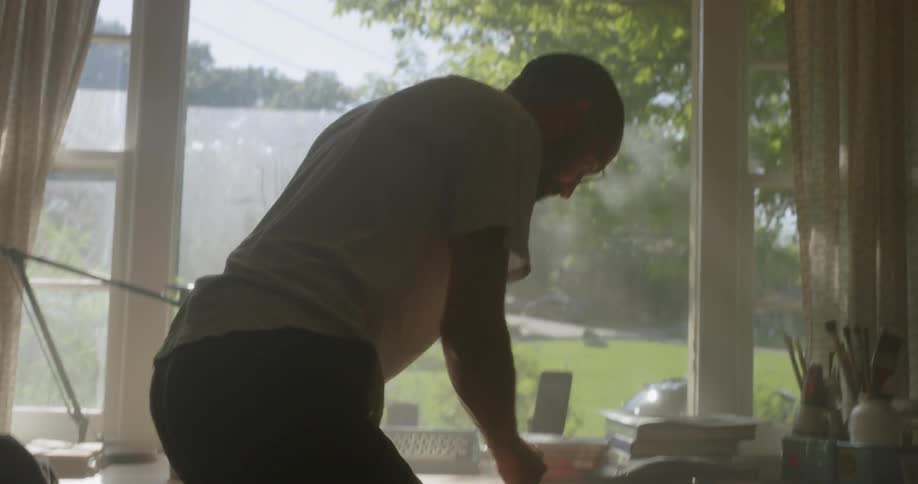 The man takes a drink then gets up