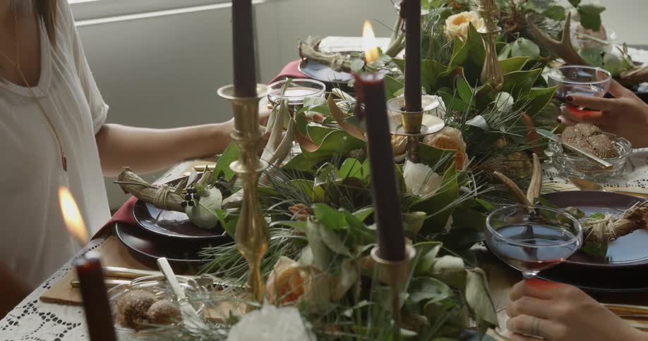 A woman sitting at a table elaborately set for a feast