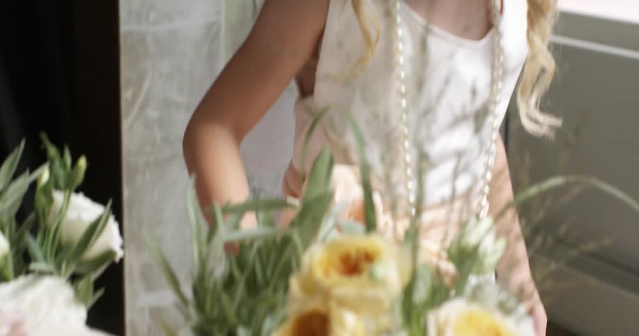 Young girl with a veil pouring tea at a flower filled table