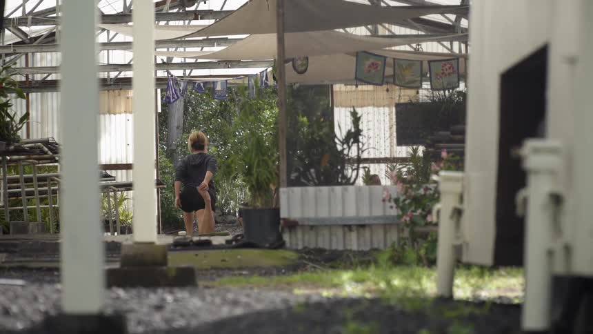 The woman is stretching in the yard