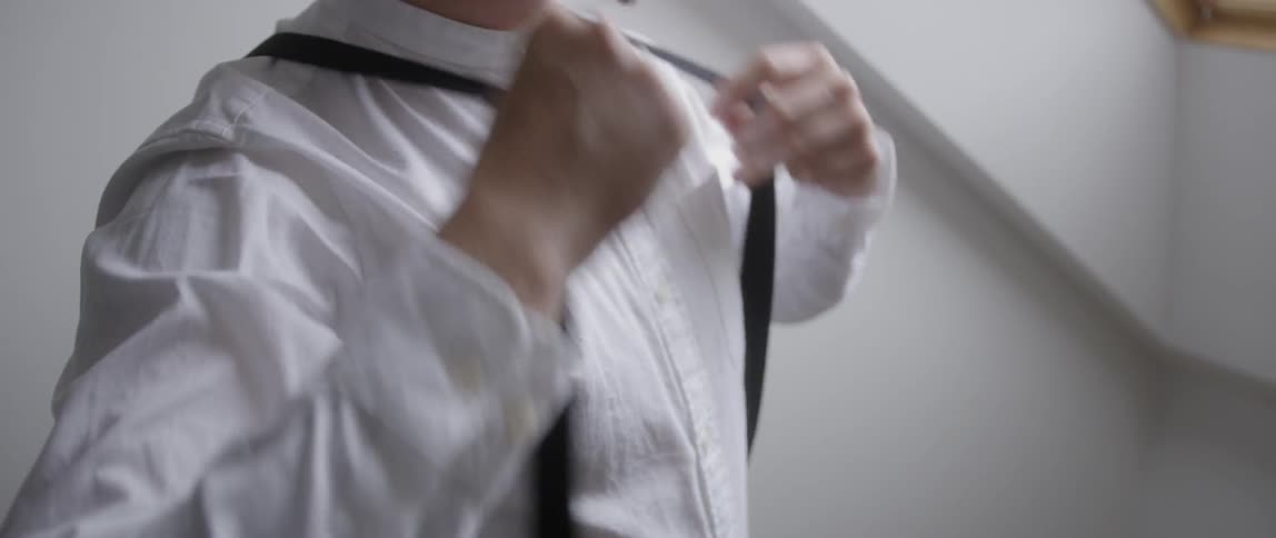 The man puts on suspenders
