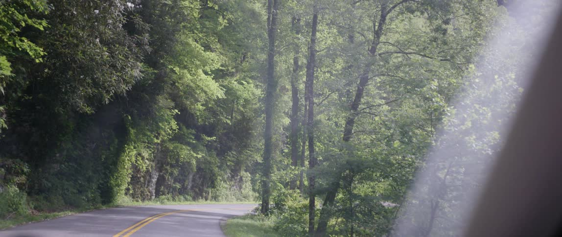 The vehicle is driving on the small road
