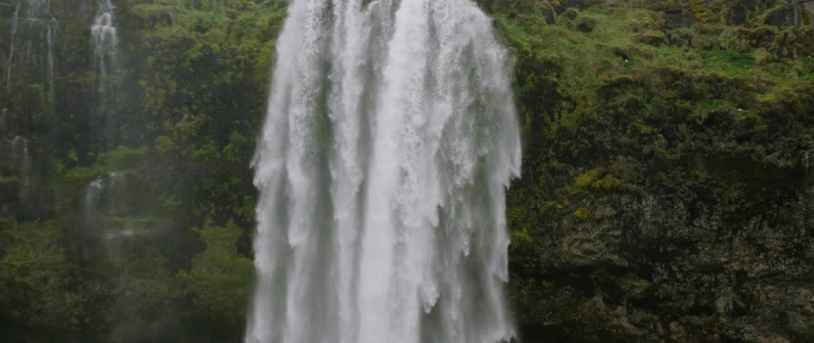 A waterfall flows over a cliff in the wilderness