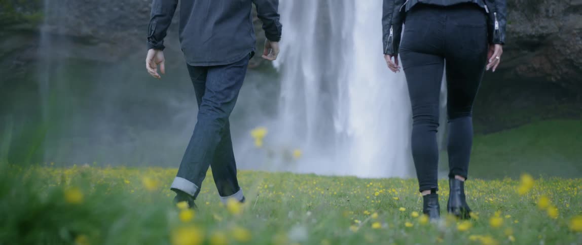 A couple approaching a waterfall